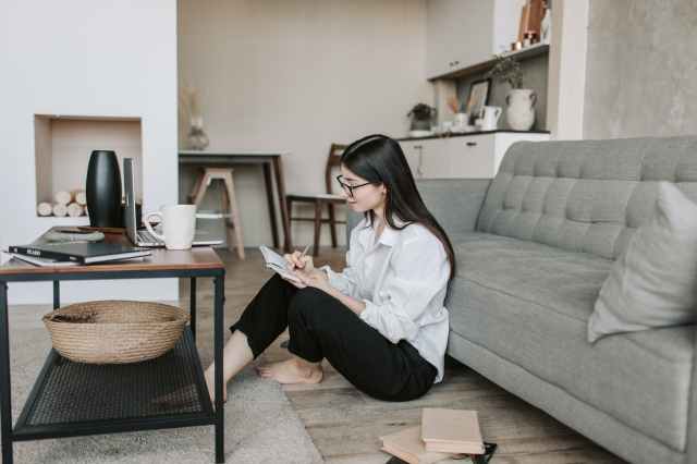 focused young lady sitting on floor in living room